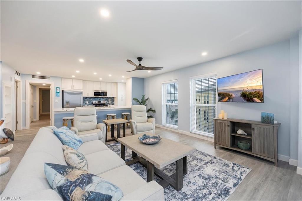 Living area with light wood-style flooring, recessed lighting, and a ceiling fan