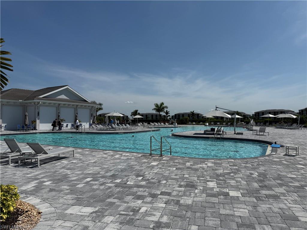Expansive private pool deck featuring multi-toned paver flooring