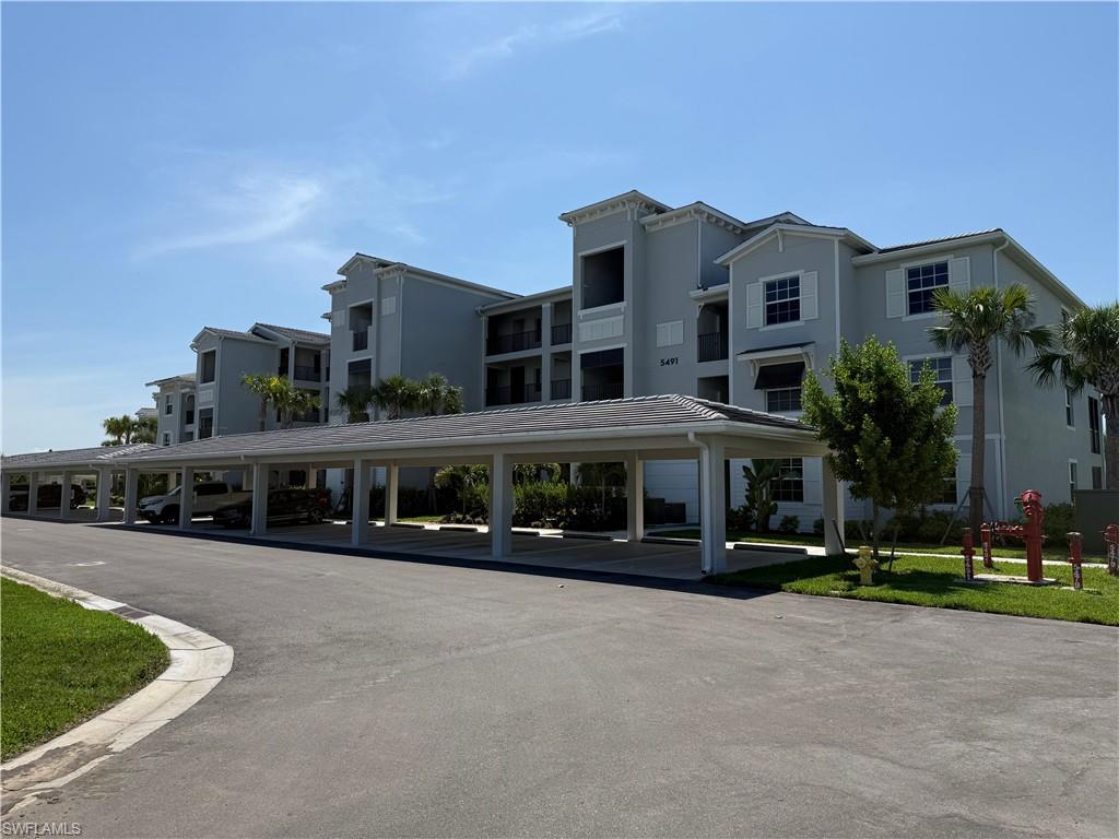 Multi-story residential structure featuring a covered parking area with multiple bays