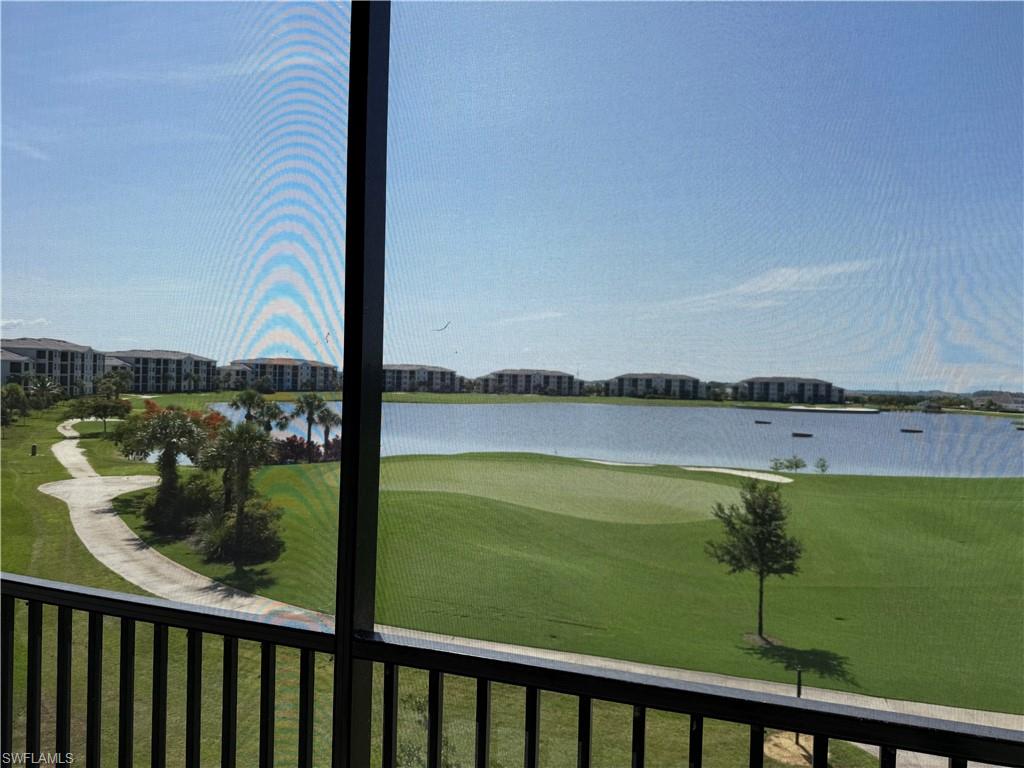 Screened lanai overlooking a golf course, expansive lake, and lush landscaping