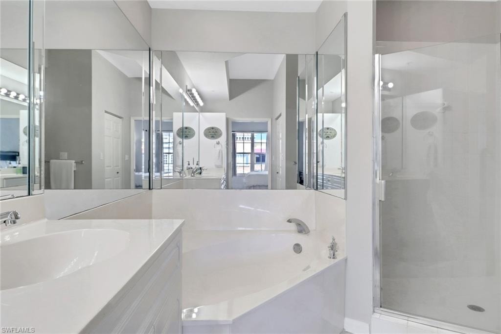 Full bathroom with a shower stall, a garden tub, and vanity