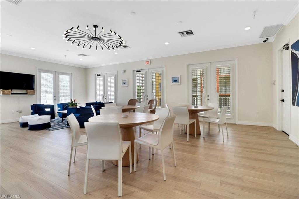 Dining room with french doors, ornamental molding, light wood finished floors, and recessed lighting