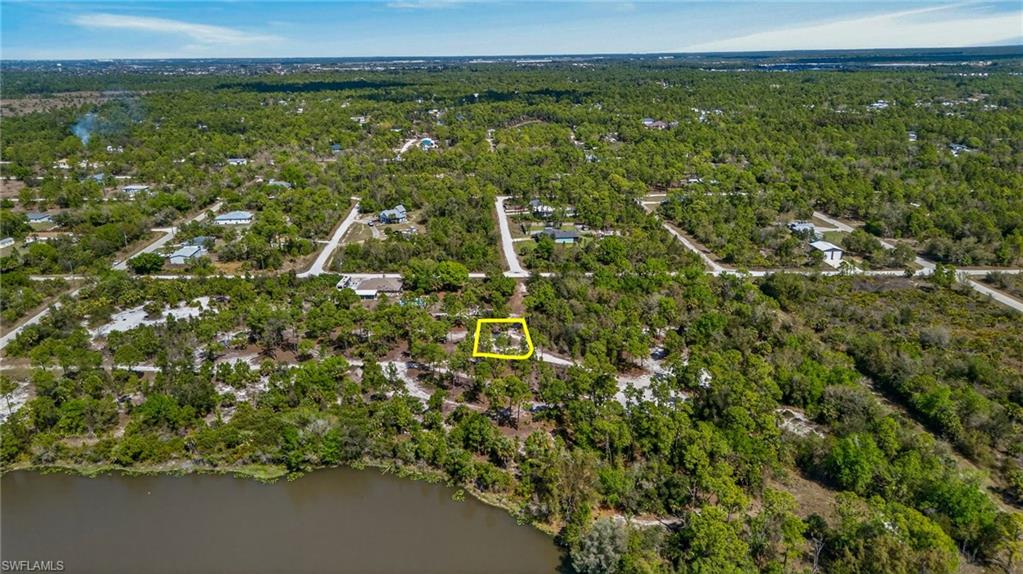 Aerial view of property and surrounding area with property boundaries highlighted and a heavily wooded area