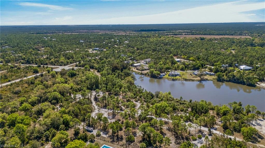 Aerial view of a heavily wooded area and a nearby body of water
