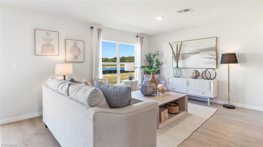 Model home. Living room featuring light wood-type flooring