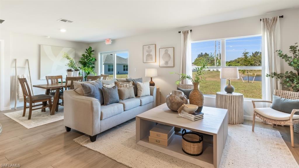 Model home. Living room featuring light wood finished floors and baseboards