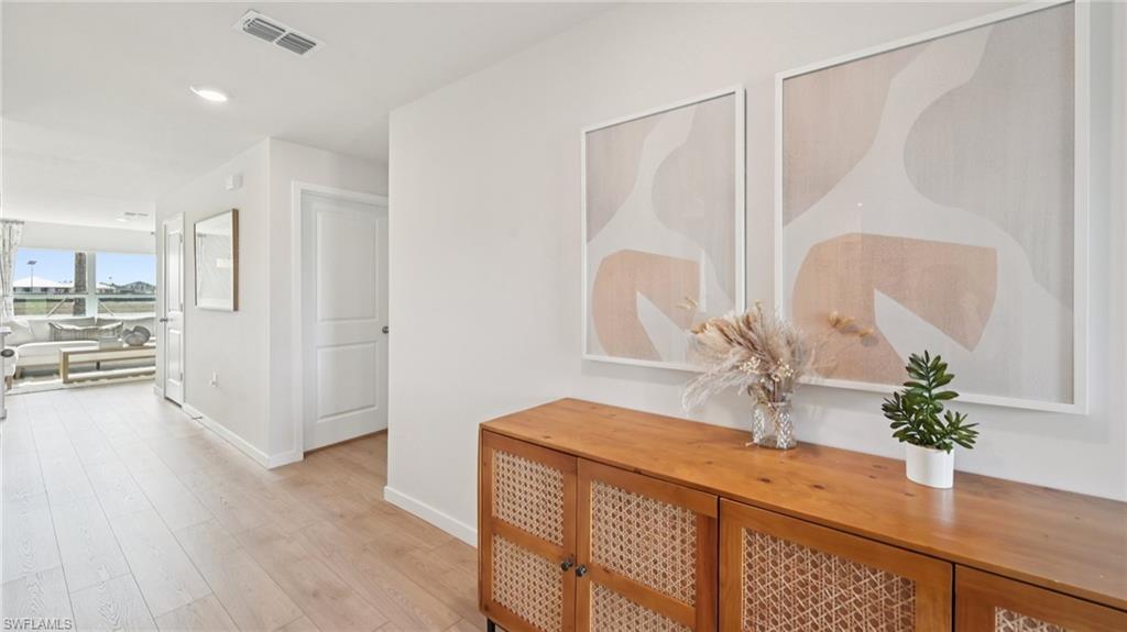 Model Home. The property features light-colored flooring throughout the entry area, leading to an open living space with expansive windows