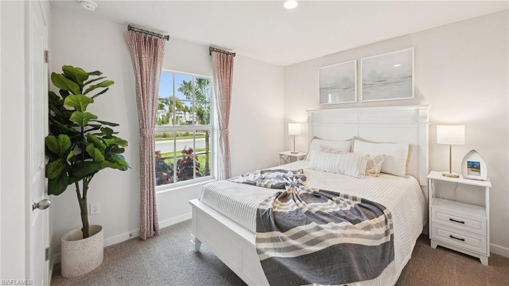 Model Home. This bedroom features light-colored walls, carpeted flooring, and a window with curtains