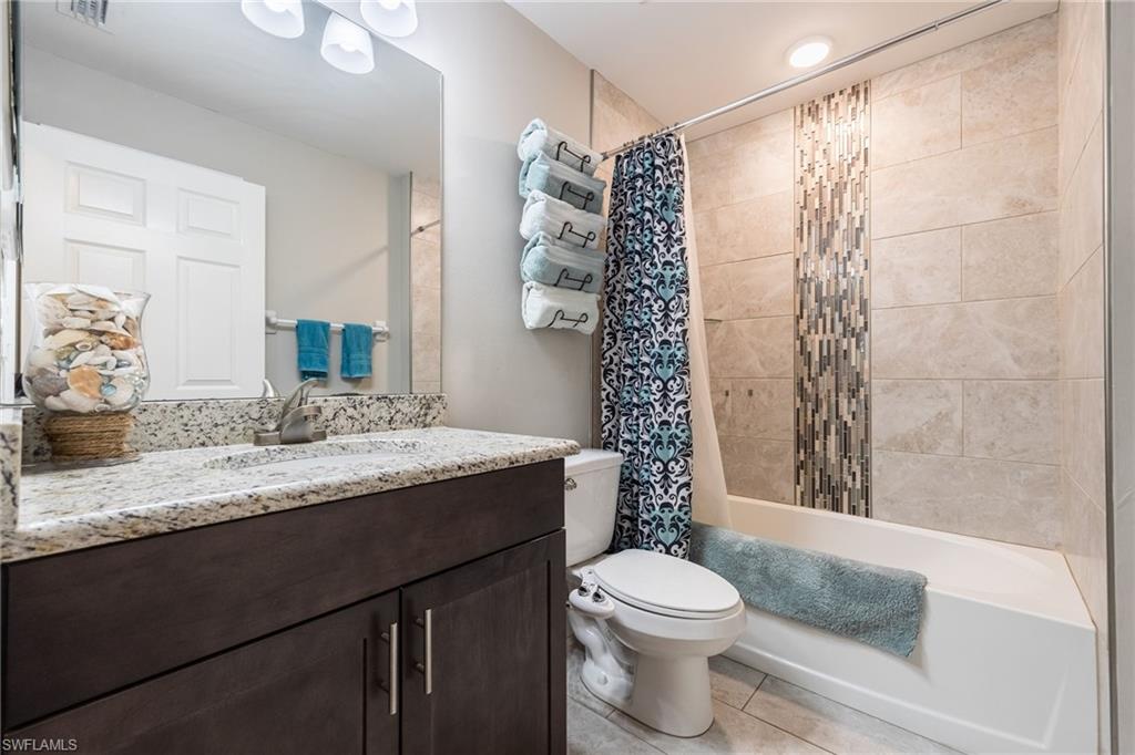 Bathroom featuring a vanity with a light-toned granite countertop and dark wood-finish cabinetry