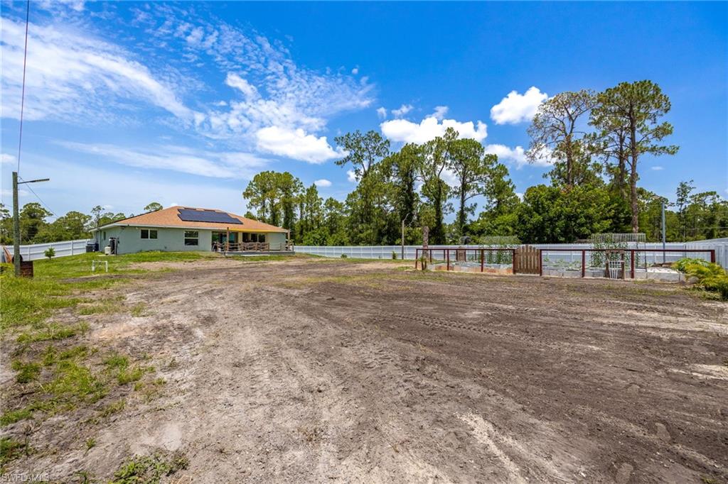 Expansive property with a fenced perimeter and a structure featuring solar panels