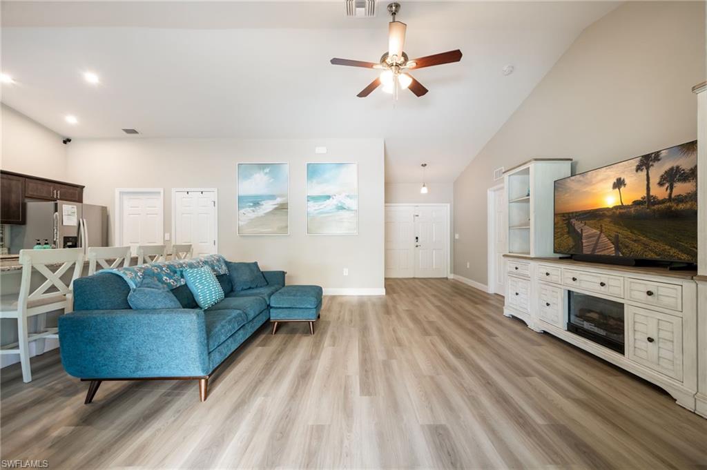 Vaulted ceilings enhance this open-concept living area with wood-finish flooring