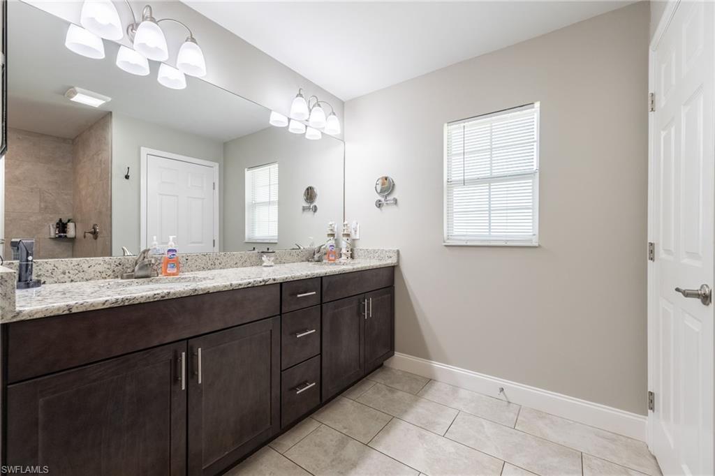Double vanity with a granite countertop and wood-finish cabinetry