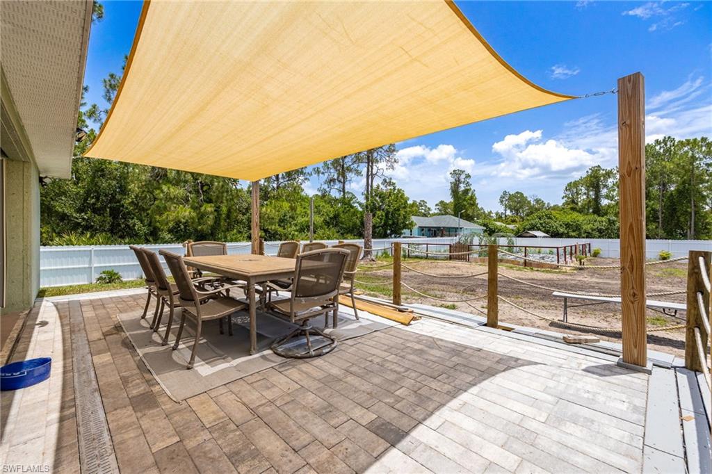 Expansive paver patio with a large shade sail, offering an outdoor dining area