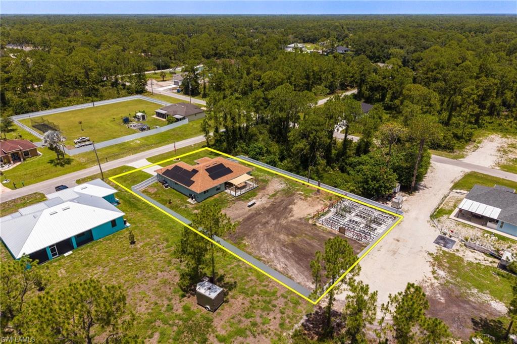 Aerial property perspective featuring a single-story residence with a brown shingle roof and solar panels