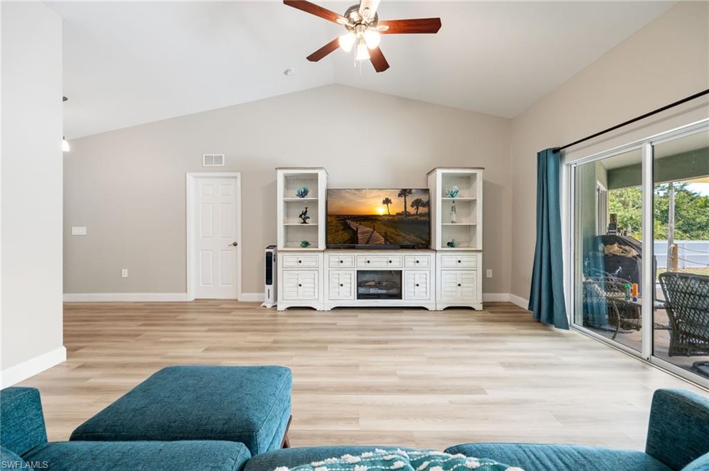 Spacious interior featuring wood-finish flooring, vaulted ceilings, and a ceiling fan