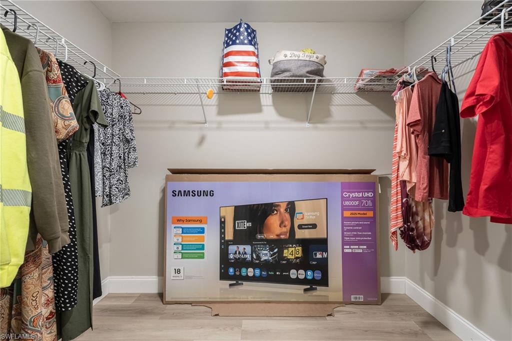 Closet with wire shelving, hanging rods, and wood-finish flooring