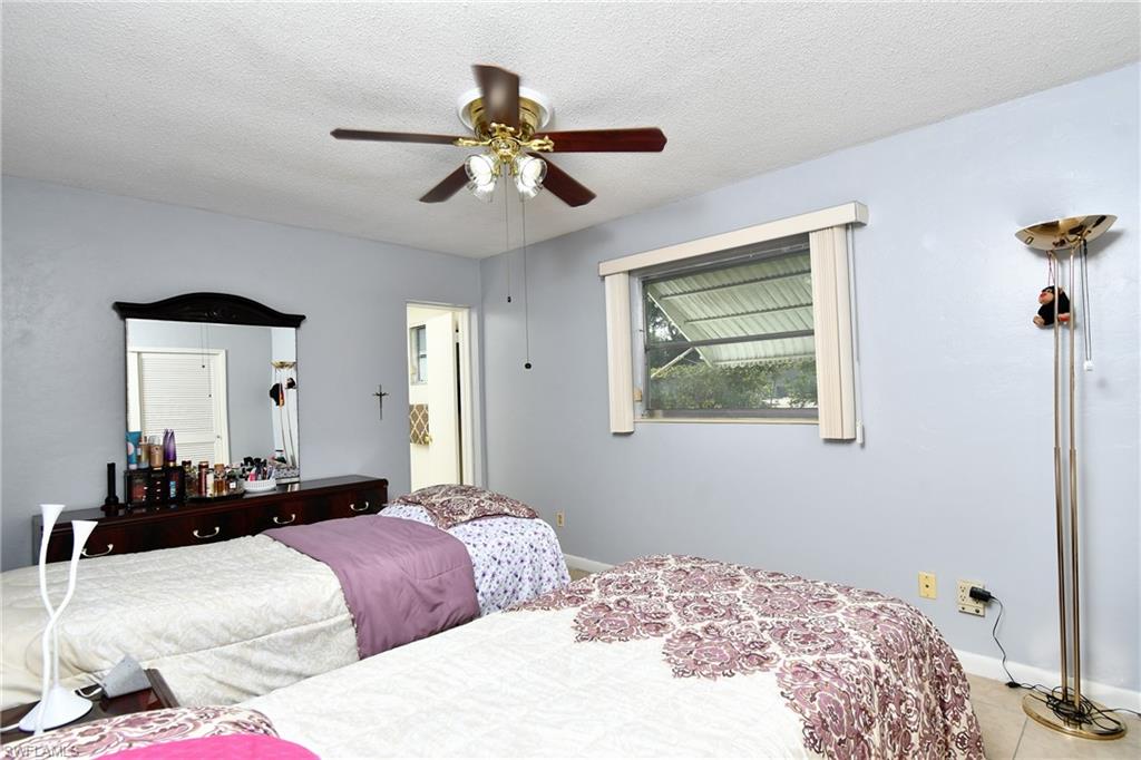 Interior space featuring light blue walls, a textured white ceiling, and light-toned tile flooring