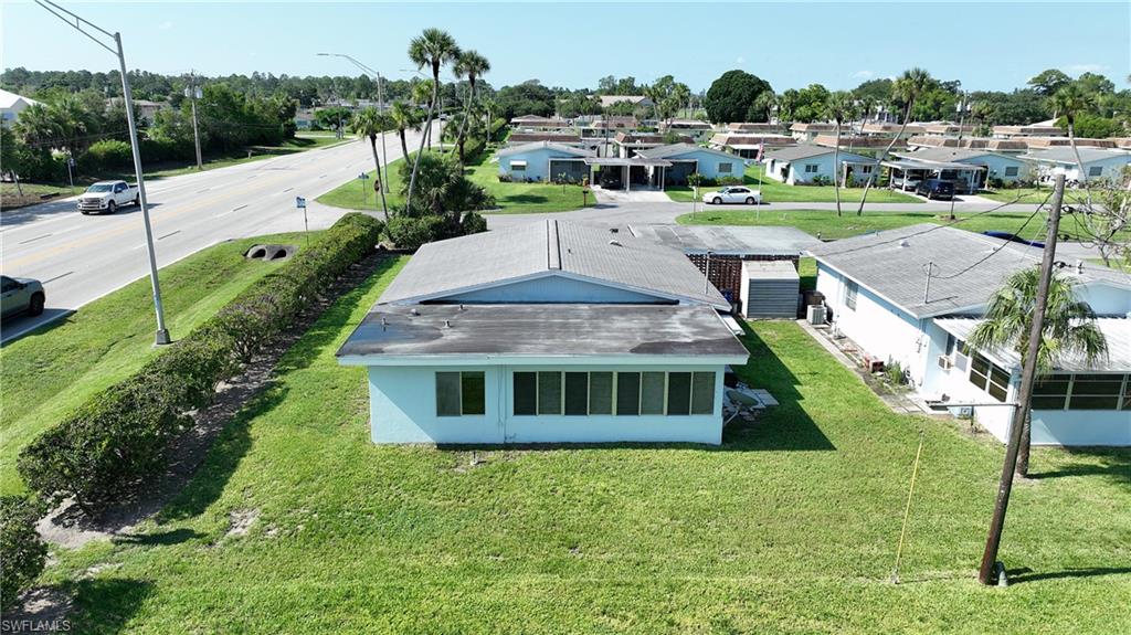 Light blue single-story residence featuring a gray shingle roof and a sunroom with multiple windows
