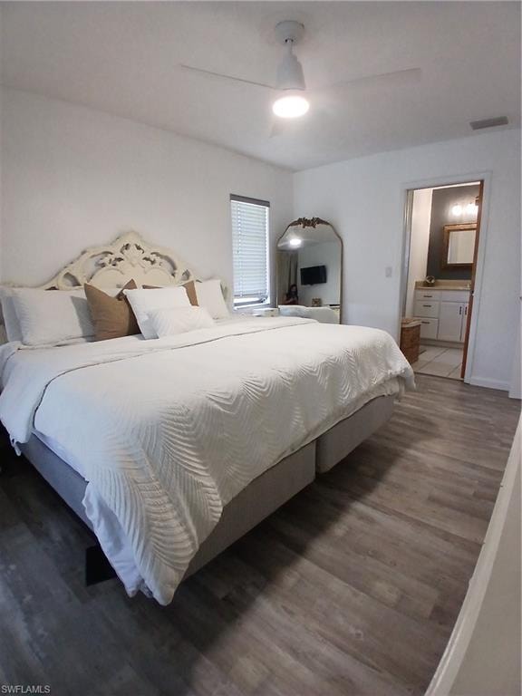 Spacious room featuring wood-finish flooring, a ceiling fan with integrated lighting, a window with blinds, and direct access to an attached bathroom