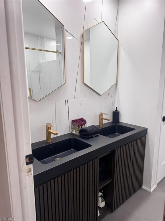 Dual vanity featuring matte black sinks and gold-finish faucets
