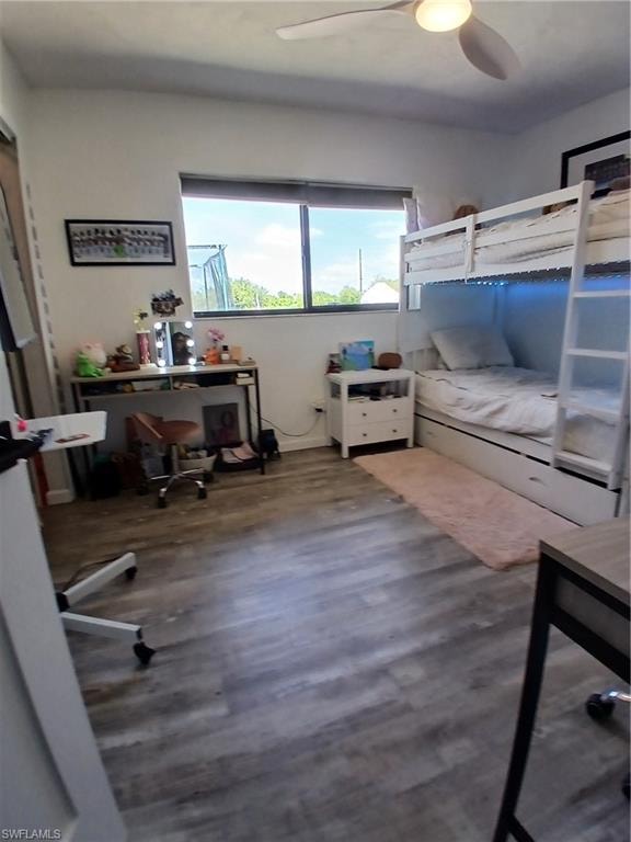 Room featuring wood-finish flooring, white walls, and a modern ceiling fan with integrated lighting