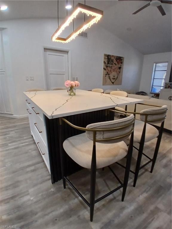 Kitchen island featuring a white countertop with dark veining, integrated storage drawers with linear pulls, and a contrasting fluted panel detail