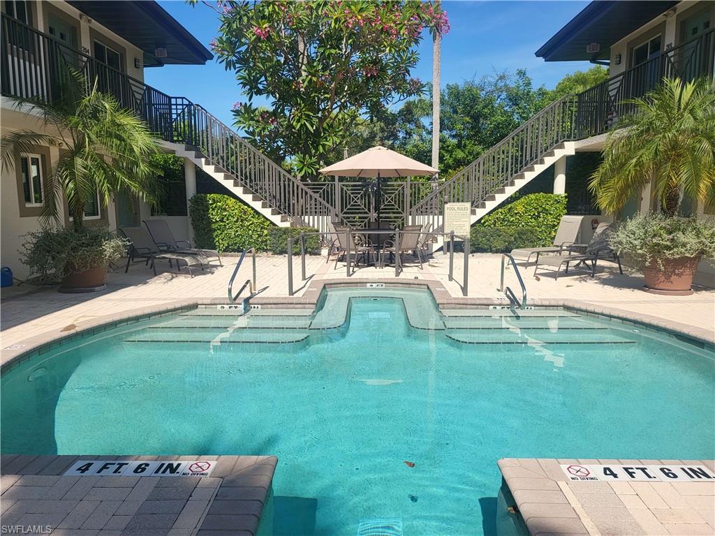 Community pool featuring stairway, a balcony, a patio, and outdoor dining space