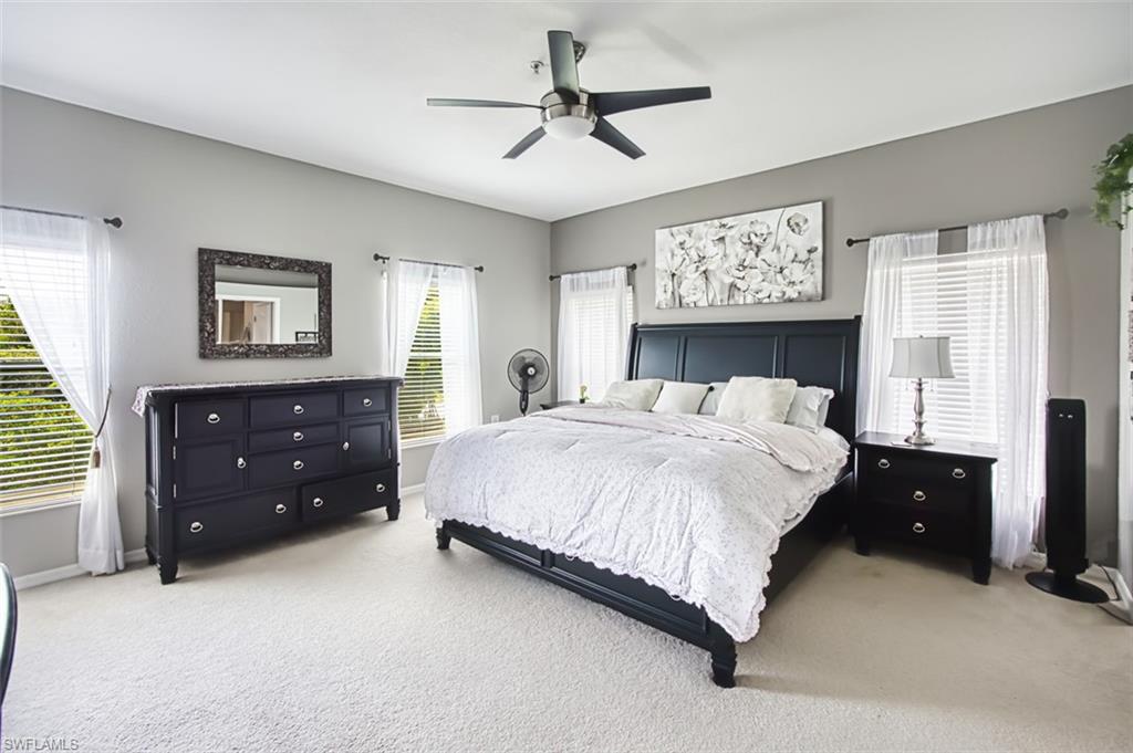 Spacious bedroom featuring light neutral wall tones and plush carpeting