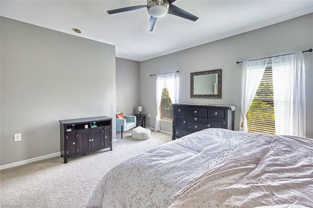 Spacious room featuring light-toned carpeting and multiple windows with blinds