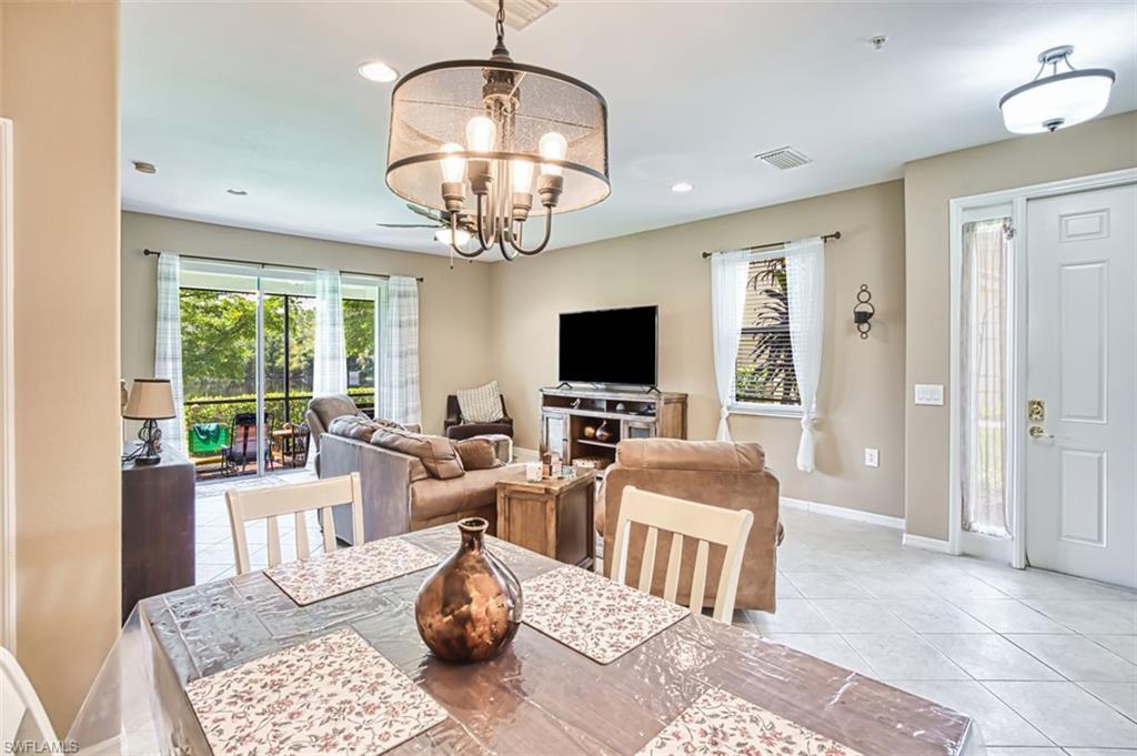 Open-concept living area featuring a decorative chandelier, recessed lighting, and tile flooring