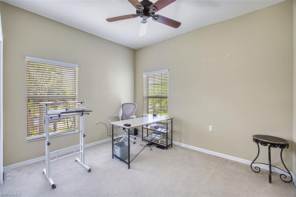 Room featuring vaulted ceilings, two windows with horizontal blinds, neutral wall paint, and light-colored carpet