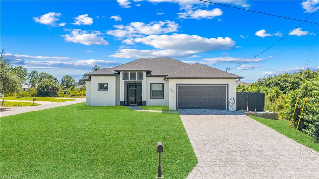 Contemporary exterior featuring a light stucco finish, dark trim, and a dark shingle roof