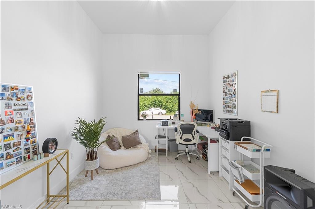 Bright room with high ceilings, featuring a single window with dark framing