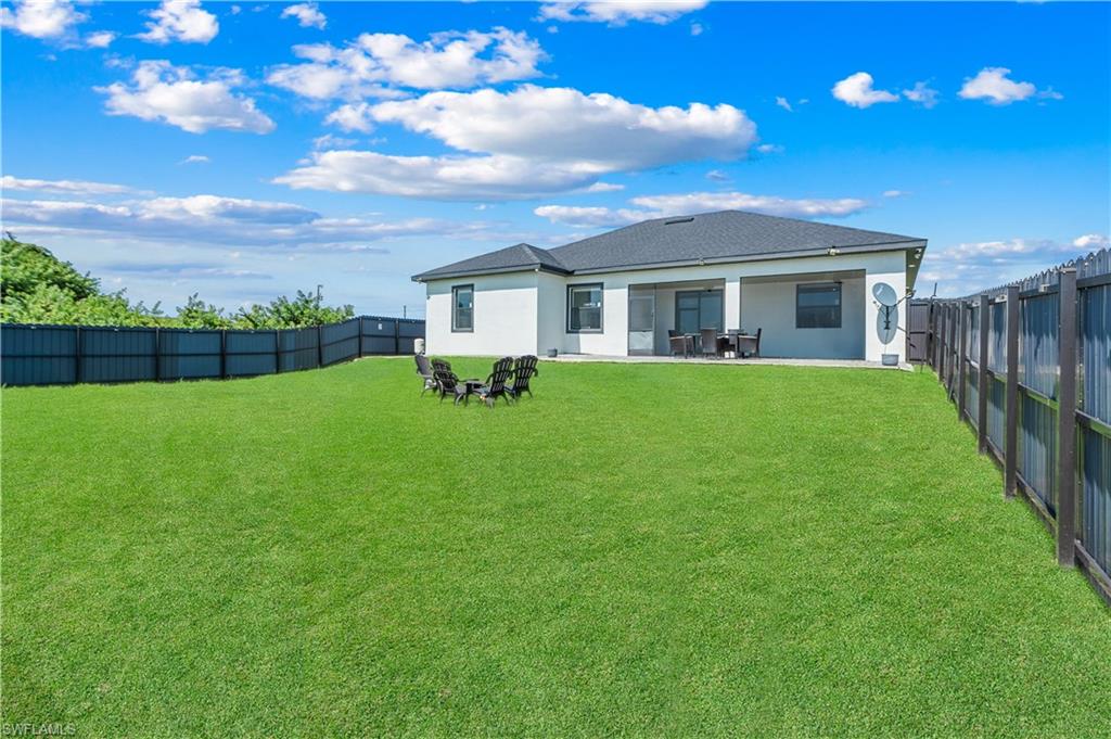 Expansive green lawn with a privacy fence