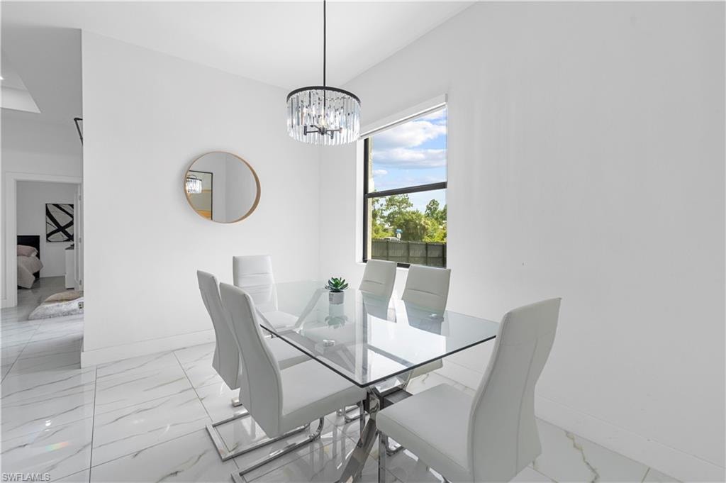 Bright dining area featuring a crystal chandelier and large window