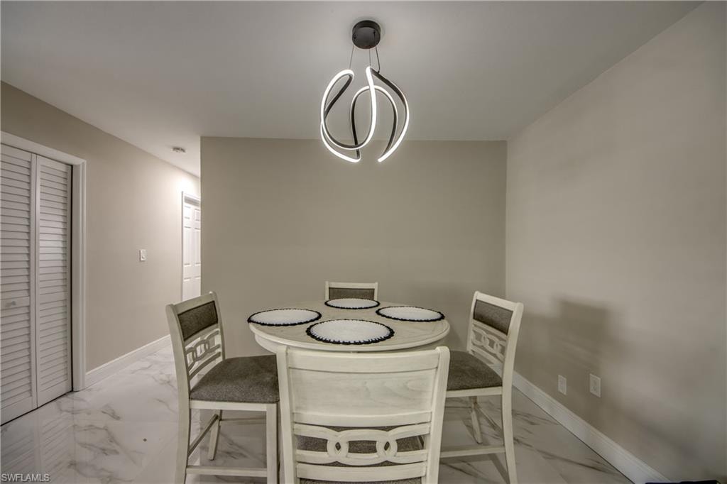 Modern ceiling light fixture illuminating a room with light-toned walls and white baseboards