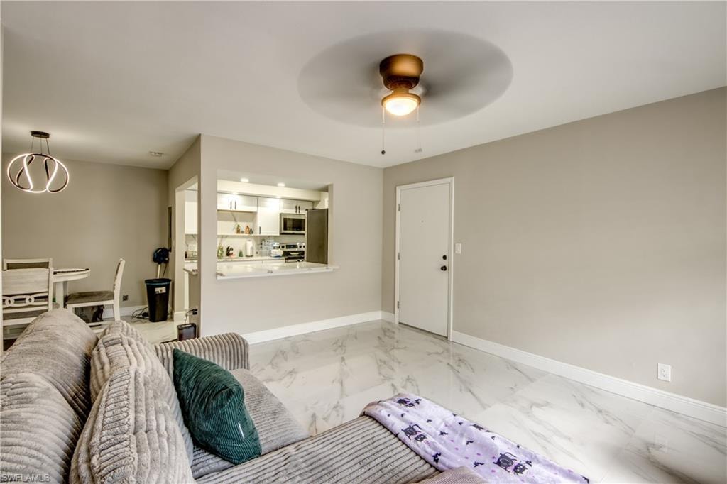 Living area with marble-look tile flooring, contemporary ceiling fan, and neutral wall tones
