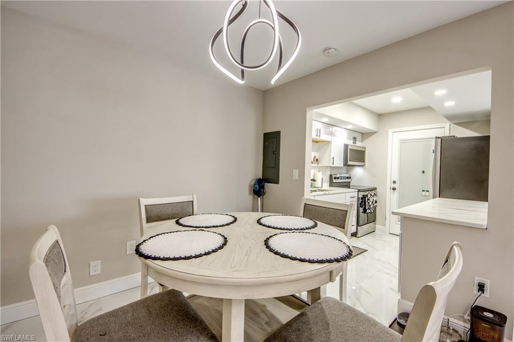 Dining area featuring a contemporary ceiling fixture, light-toned walls, and wood-finish flooring