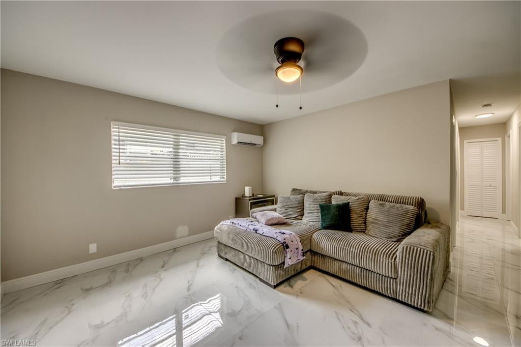 Living area featuring expansive white marble-look flooring, neutral wall paint, and a window with horizontal blinds