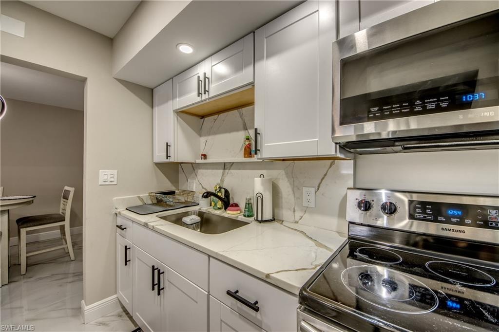 Modern kitchen featuring white shaker-style cabinetry with matte black hardware