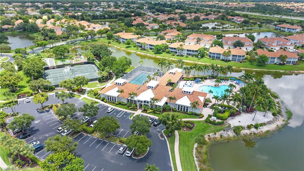 Community amenities featuring a central clubhouse with a swimming pool, multiple tennis courts, and ample parking