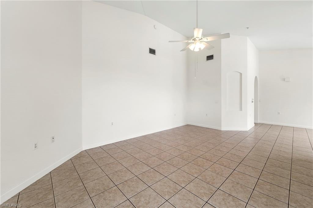 Expansive room with neutral tile flooring and white walls