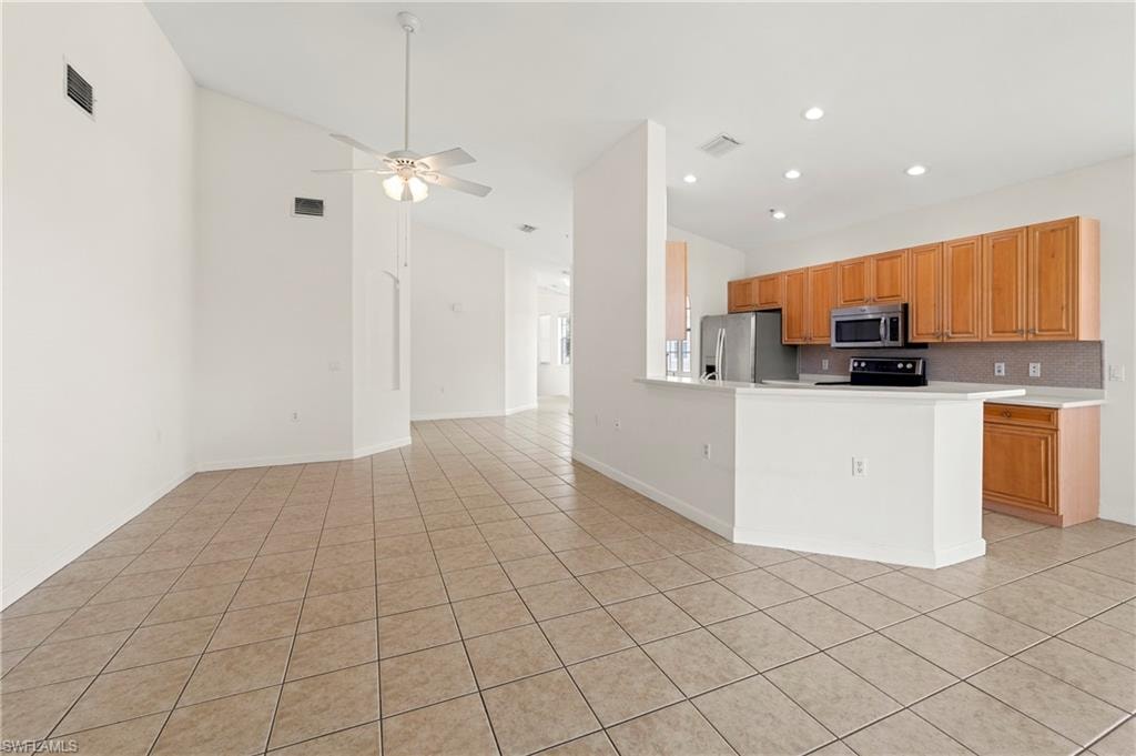 Spacious interior featuring vaulted ceilings and diagonal tile flooring