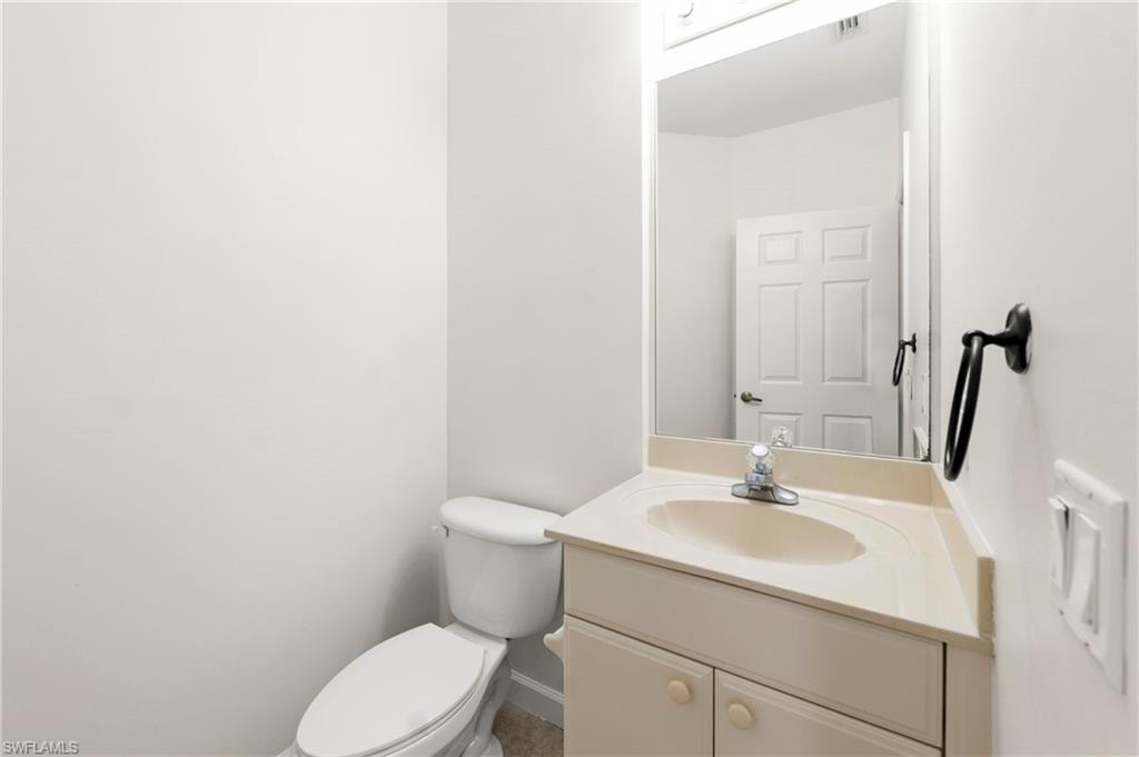 Bathroom vanity featuring an integrated sink with single-handle faucet, under-cabinet storage, and an overhead lighting fixture