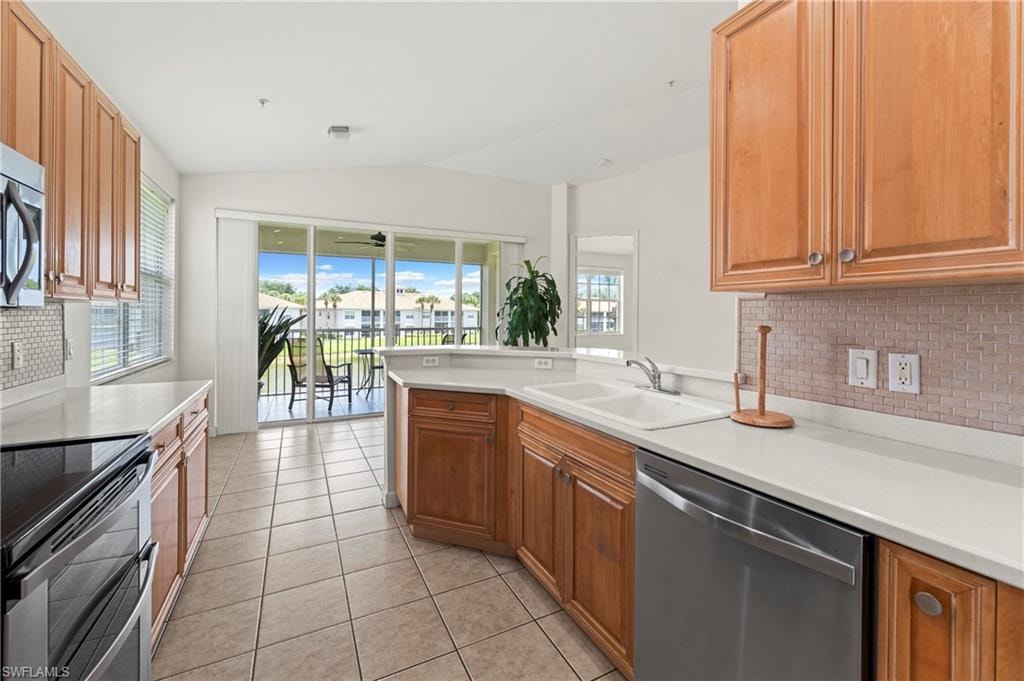 Open kitchen featuring wood cabinetry, light countertops, and tile flooring