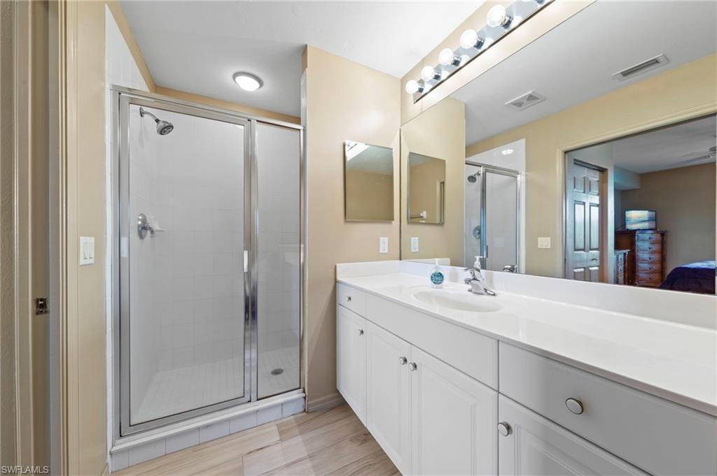 Bathroom featuring a spacious vanity with white cabinetry and a light-colored countertop