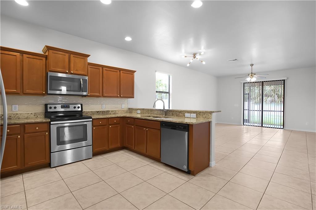 Kitchen featuring wood cabinetry, stainless steel appliances, speckled countertops, and a tiled backsplash