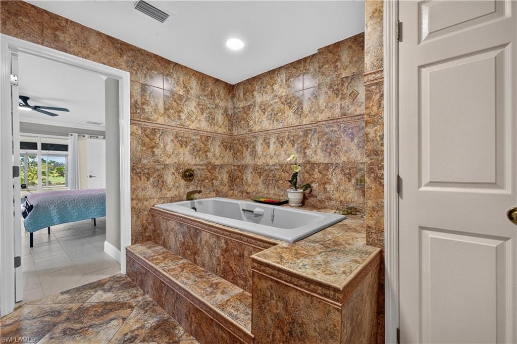 Tiled soaking tub featuring integrated steps and coordinated wall and floor tiling