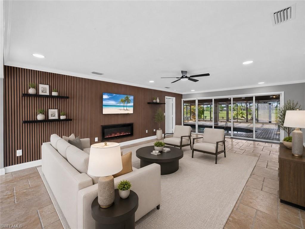 Living area featuring a slat wood-finish accent wall with an electric fireplace, recessed lighting, and a ceiling fan, virtually Staged