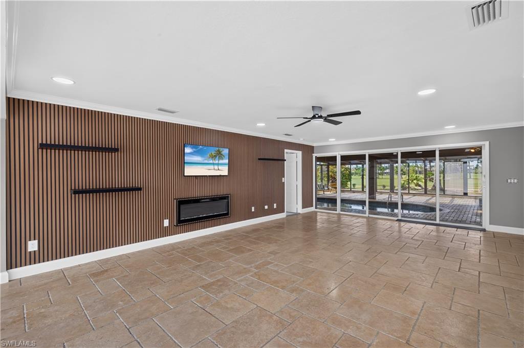 Spacious room featuring a slat accent wall with an inset electric fireplace, recessed lighting, and a ceiling fan
